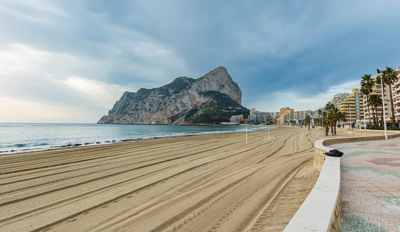 Goudkleurig zand van het strand van San Juan met bergen op de achtergrond
