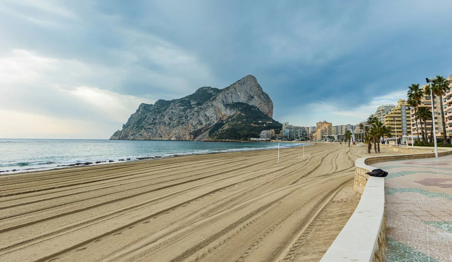 Arena dorada de la playa de San Juan con montañas al fondo